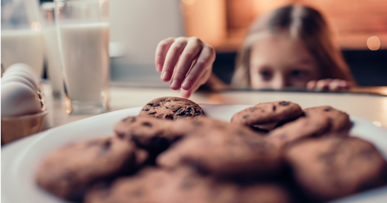 Girl sneaking cookie