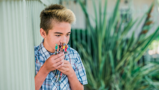 Middle school boy smelling smencils